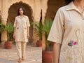 Woman wearing a beige embroidered kurta with a close-up of the garment in an outdoor setting.